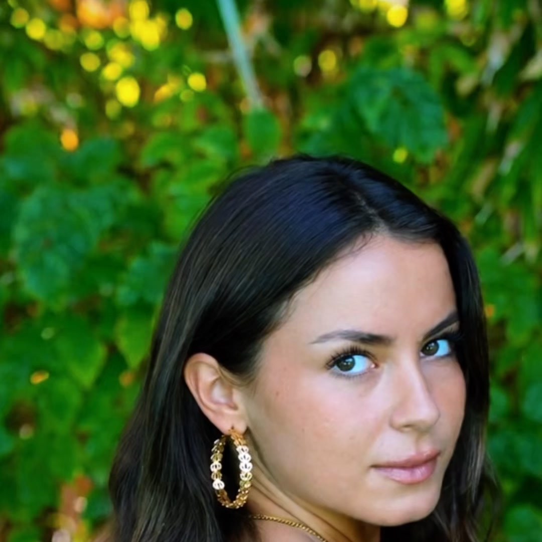 Grand Padma lotus-link hoops worn in an over-the-shoulder portrait