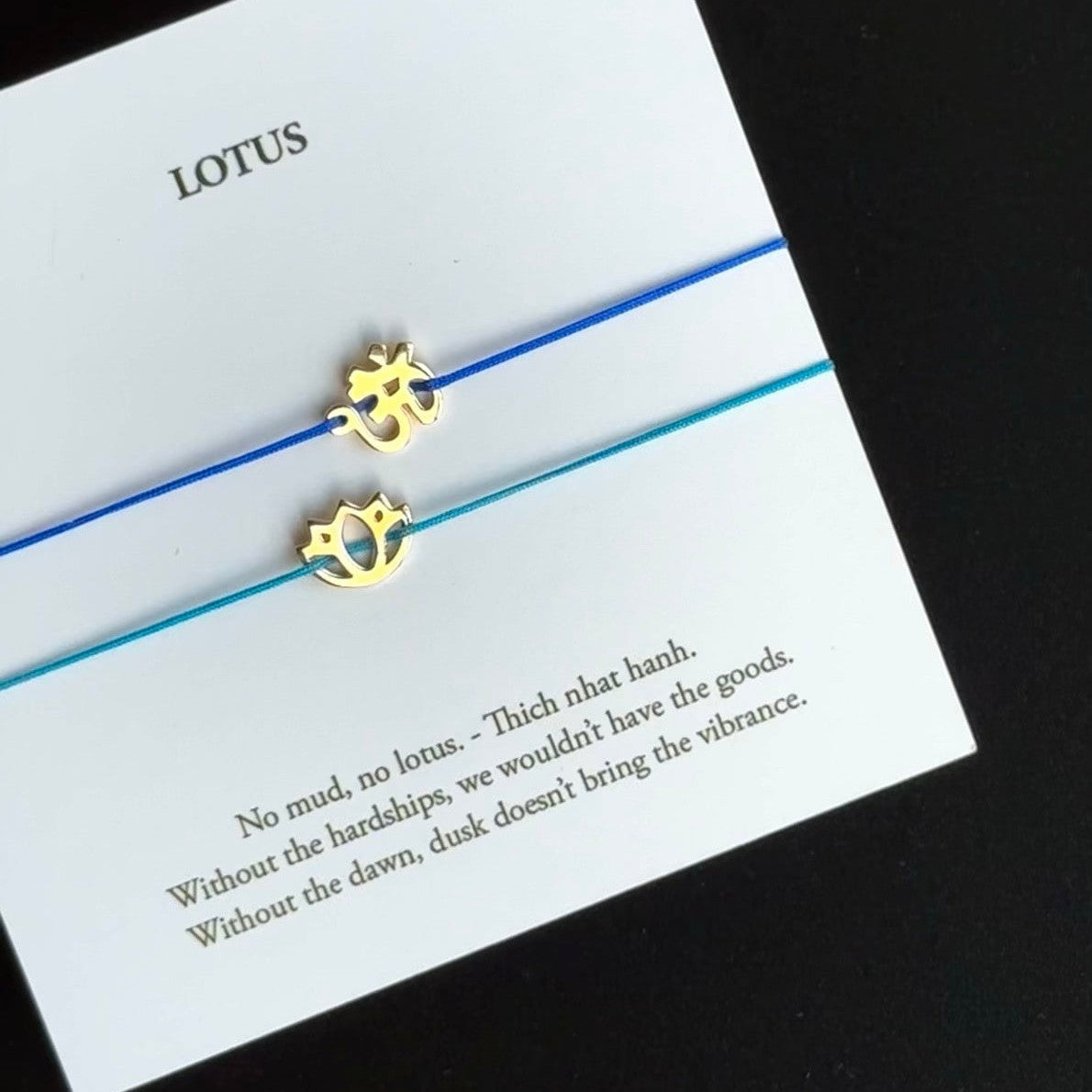 Blue and teal cord OM charm bracelets displayed on a meaning card